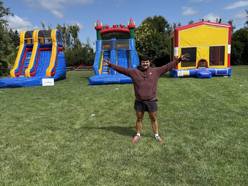 A Napa Valley Jumpers owner in front of three inflatables set up on a school field
